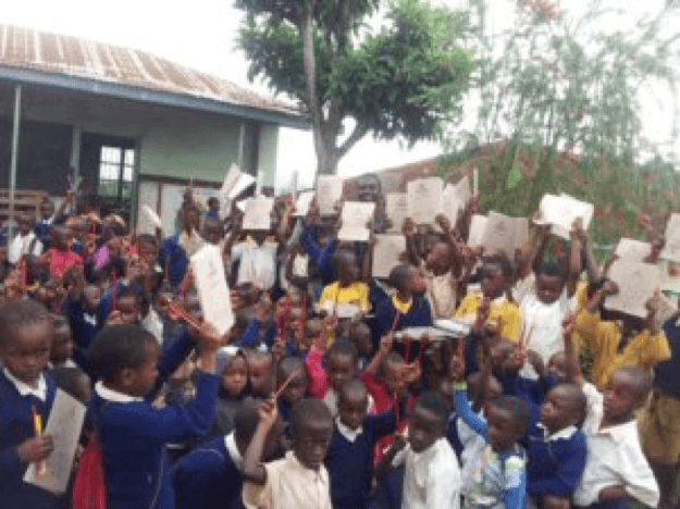 A group of happy children celebrating the work of Kilimanjaro Childlight Foundation