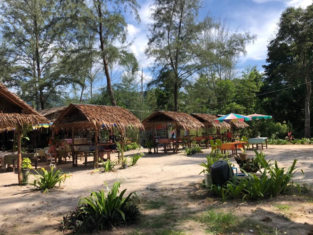 A beachside bar with chairs and tables and colourful umbrellas