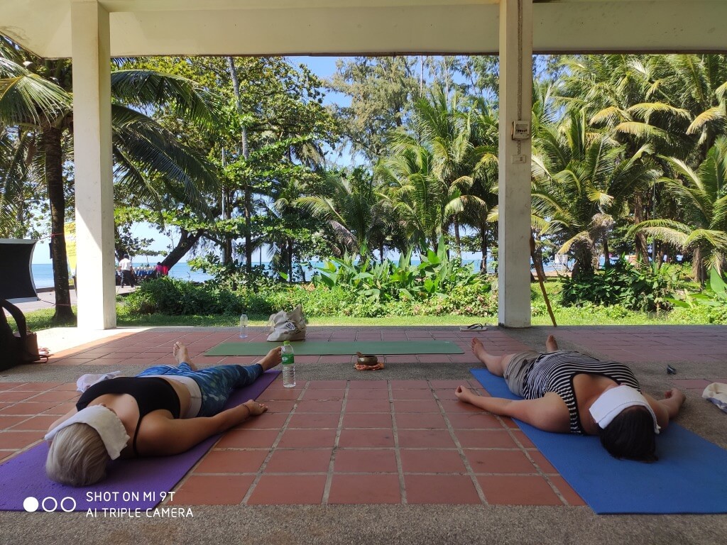 Two people lying on yoga mats meditating.
